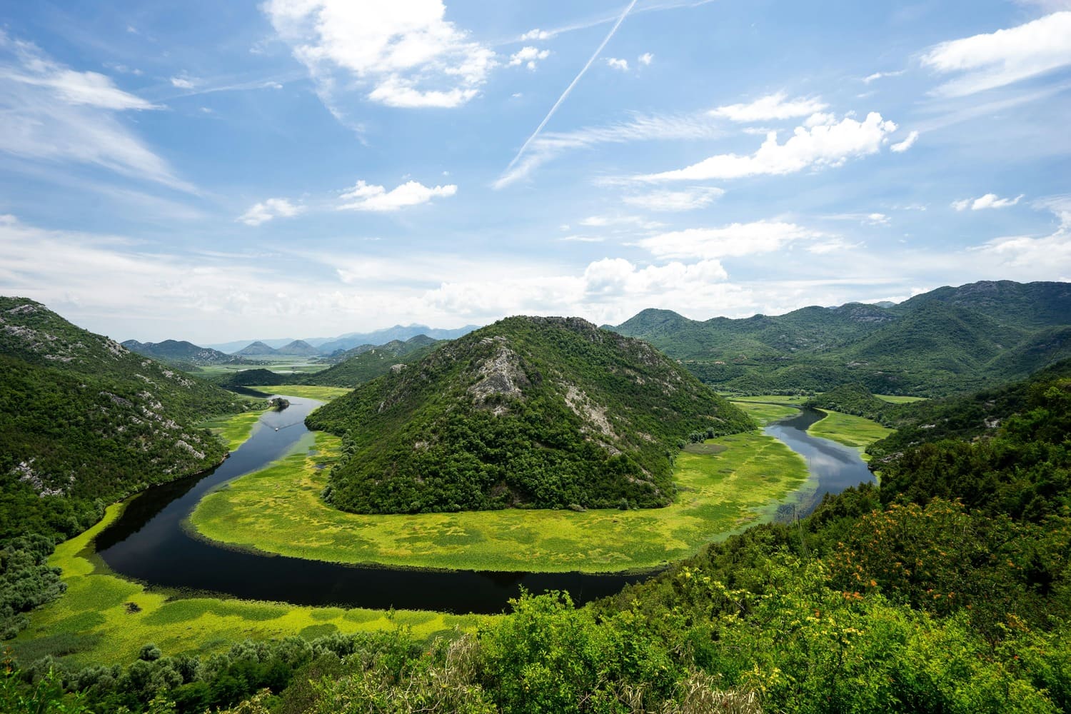 A serene, picturesque view of Lake Shkoder, showcasing its vibrant green surroundings and tranquil waters, set against the backdrop of Albania’s stunning nature.