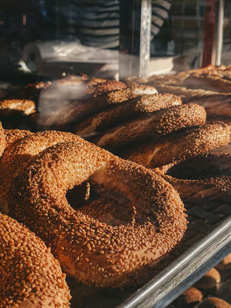Freshly baked sesame-covered koulouri bread rings in a Thessaloniki bakery window – traditional Greek street food