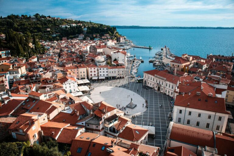 Aerial view of the coastal town of Piran, Slovenia with its red rooftops, central square, and scenic Adriatic Sea – a highlight of Balkan travel