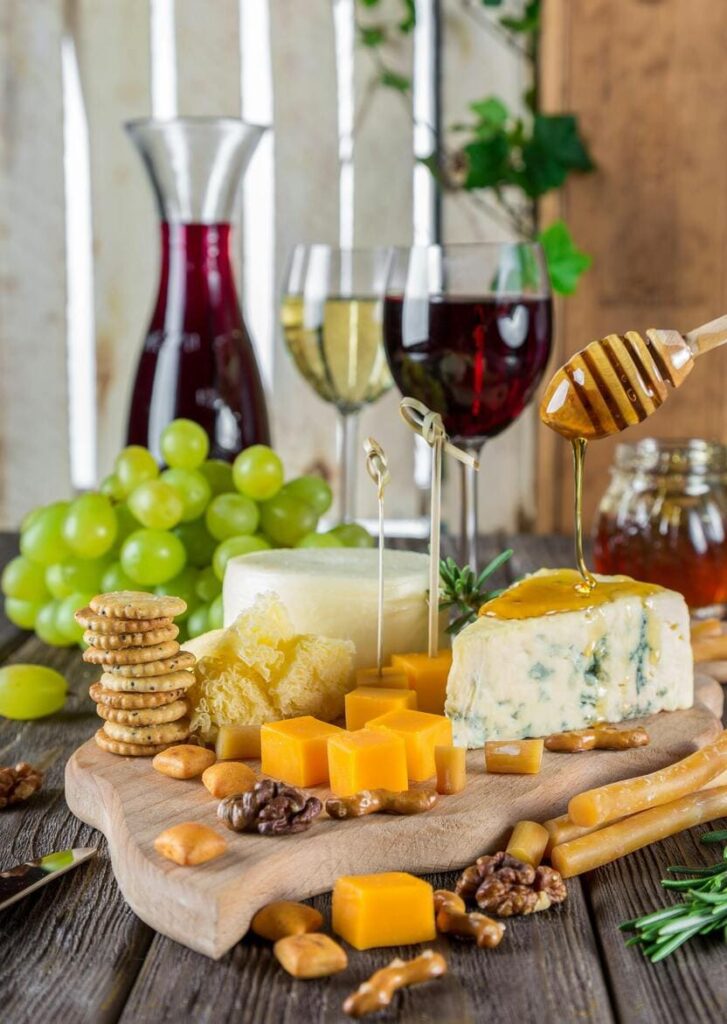 Wine glasses paired with a plate of assorted cheeses, showcasing Istria’s rich culinary heritage.