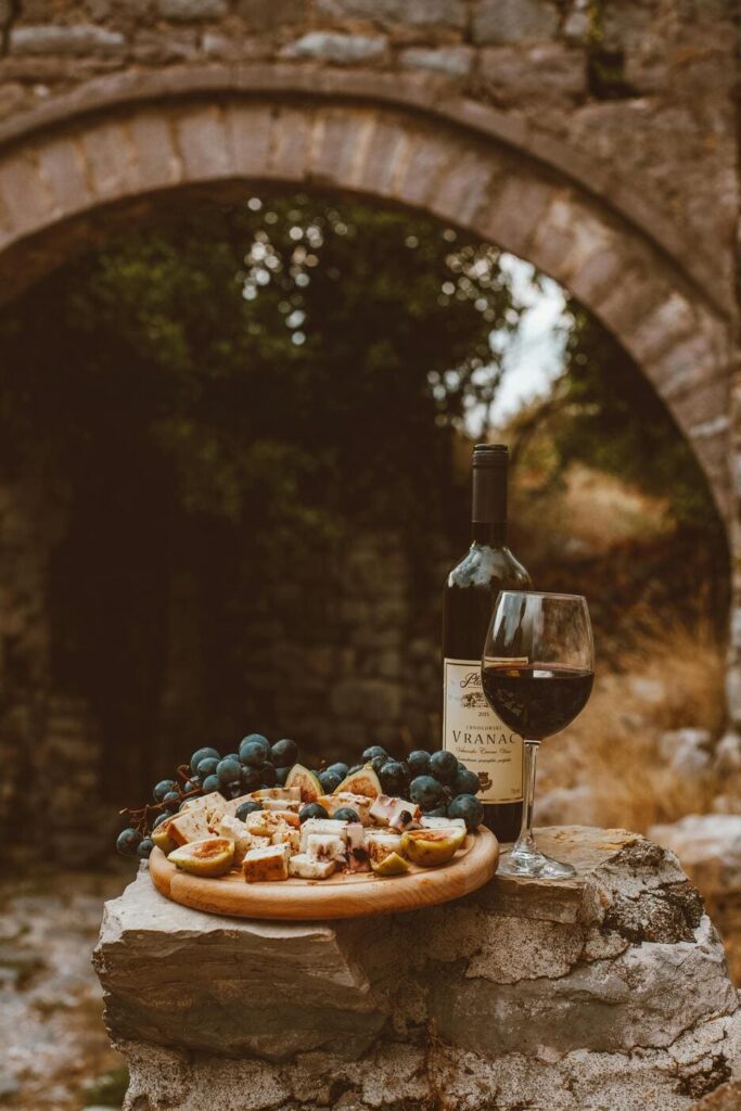 A rustic Serbian platter featuring local wines and cheeses, set against the peaceful backdrop of the countryside, offering a taste of the region’s rich culinary heritage.