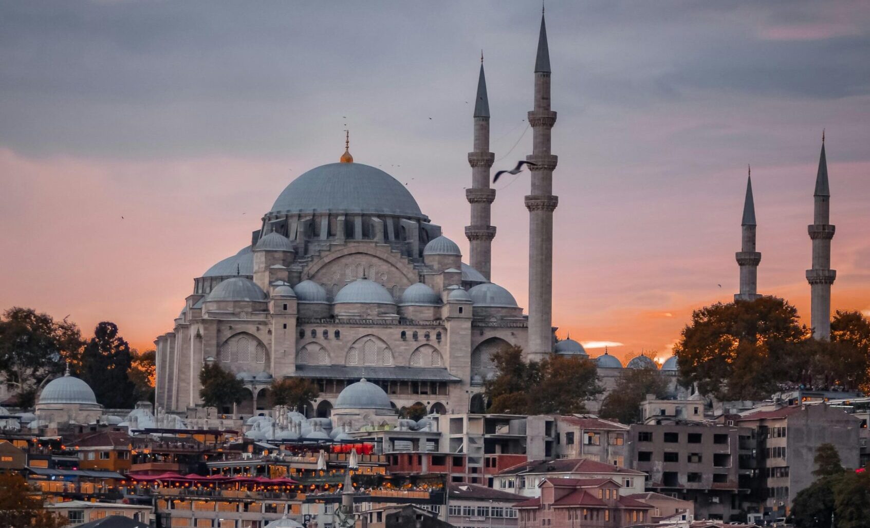 A mosque silhouetted against a breathtaking sunset in Istanbul, highlighting the rich Islamic heritage of the region.