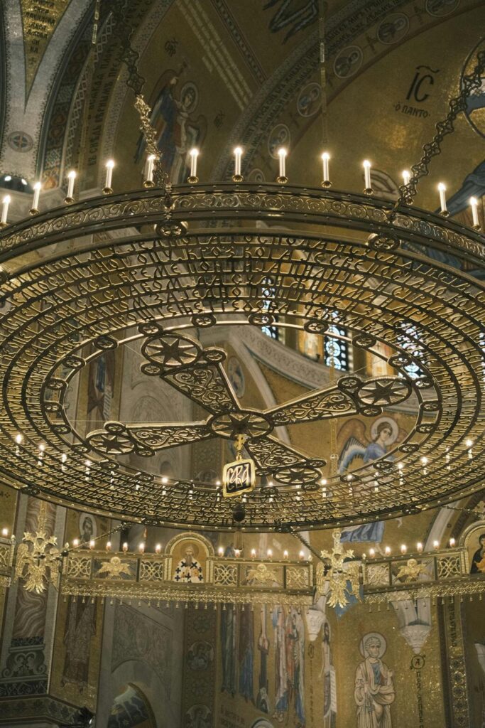 An ornate chandelier hanging in an Orthodox Church, capturing the grandeur of Eastern Orthodox religious spaces.