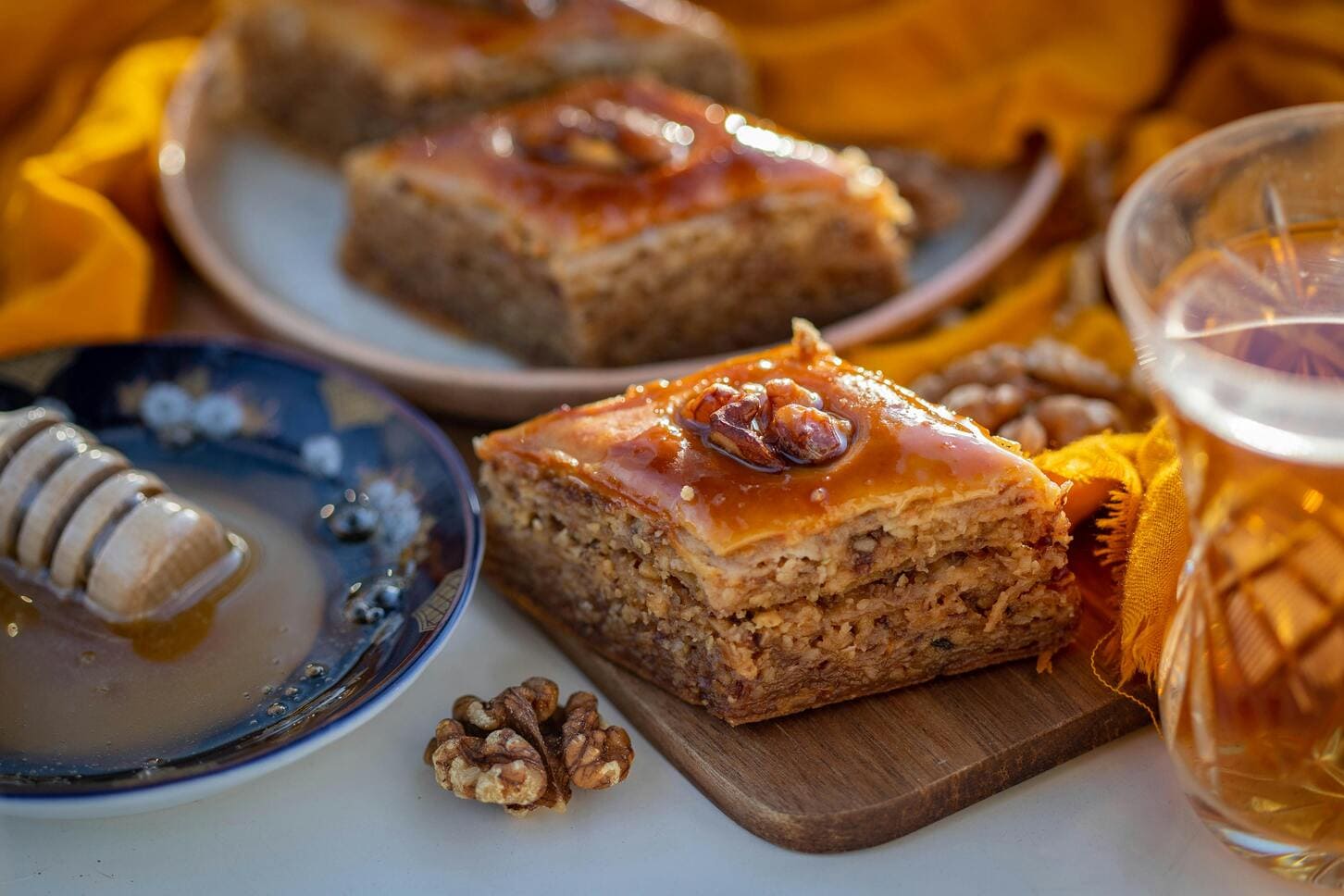 Close-up of a juicy walnut baklava, showcasing layers of flaky pastry and rich, nutty filling drenched in sweet syrup.
