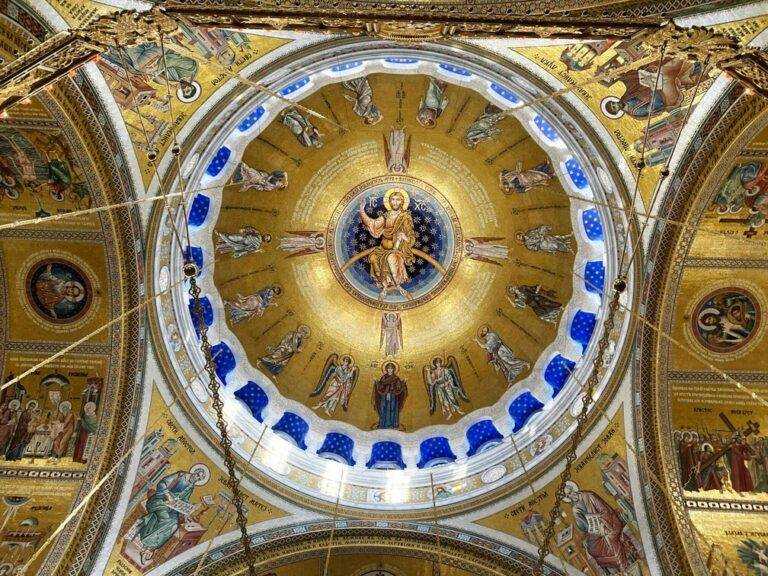Golden painting of Christ Pantokrator on the ceiling of an Eastern Orthodox Church, showcasing intricate Byzantine artistry.